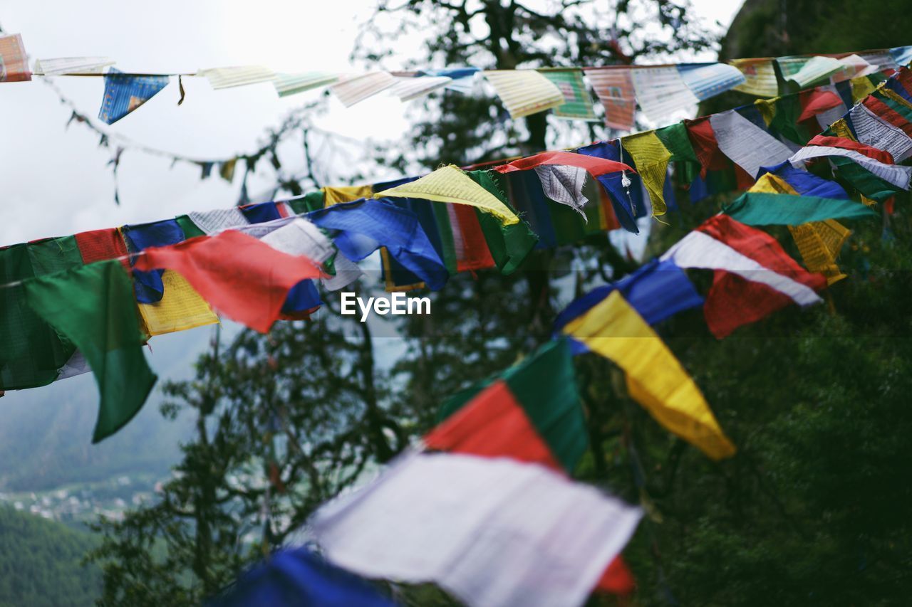 Low angle view of multi colored flags hanging against sky