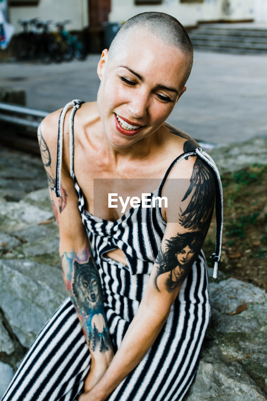 Young woman with shaved head smiles