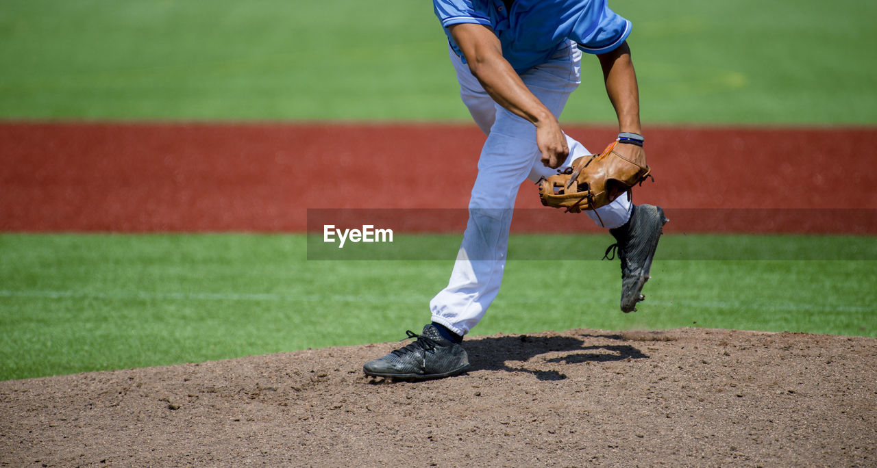 Low section of man playing baseball on field