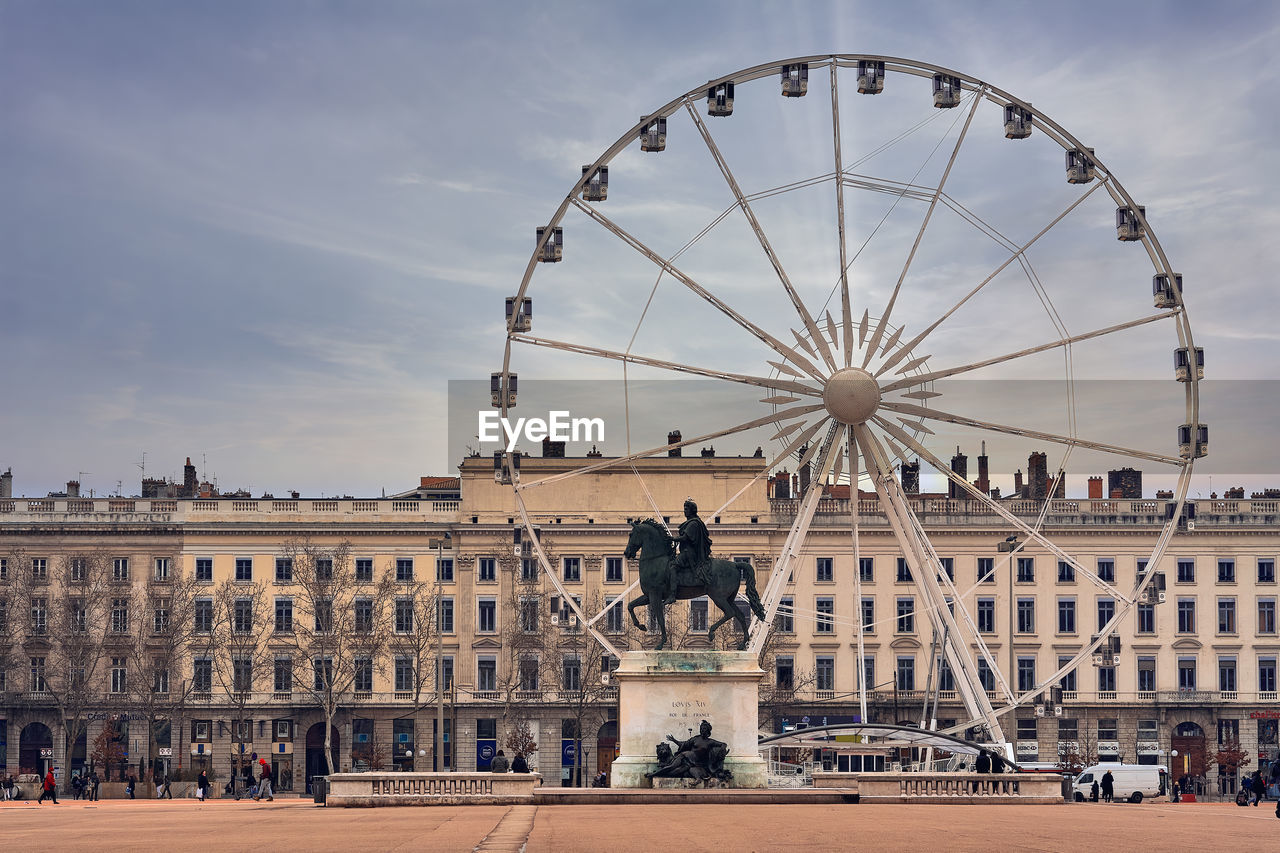 Bellecour square with louis xiv statue and a big ferris wheel
