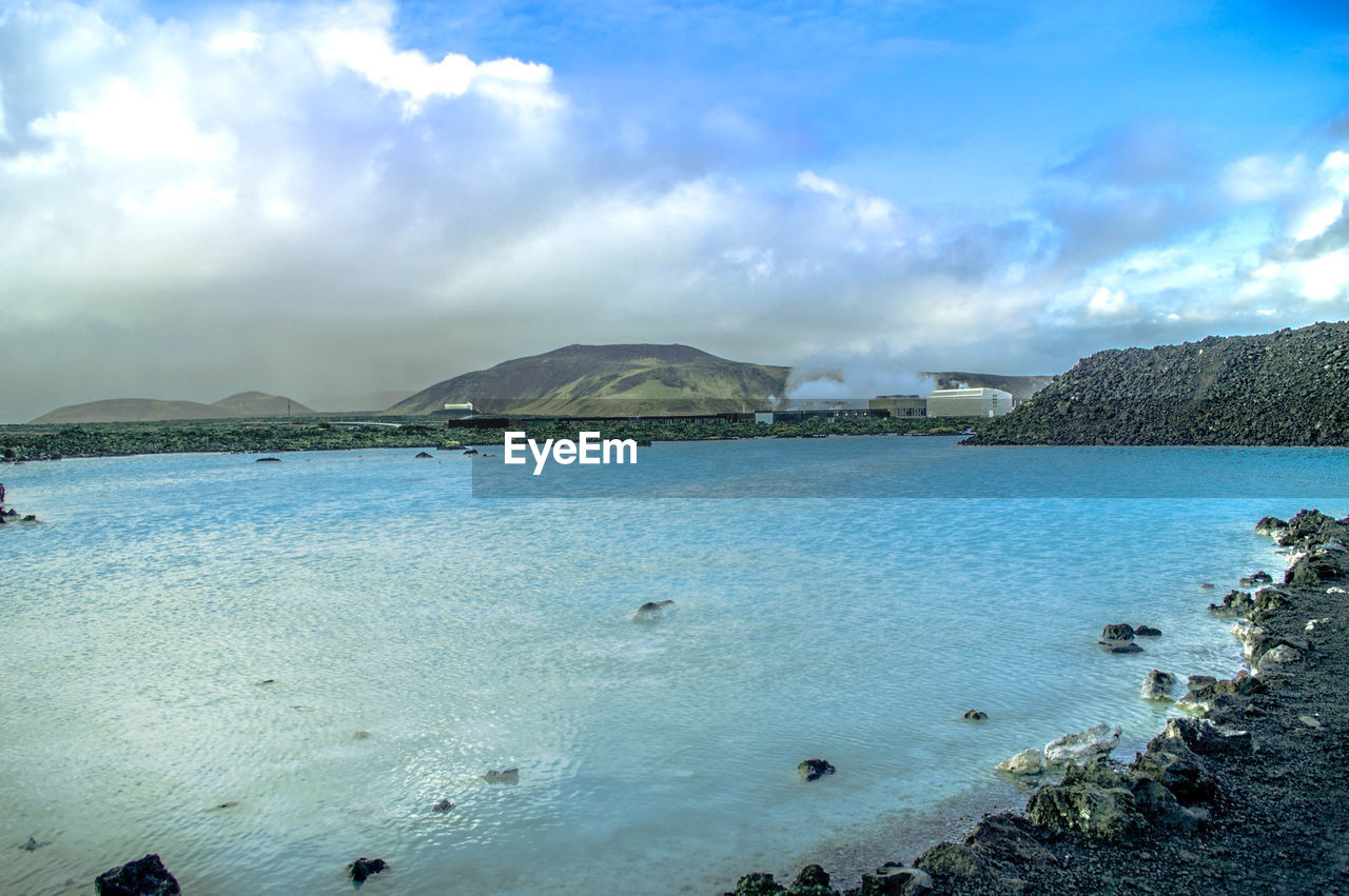 Scenic view of beach against cloudy sky