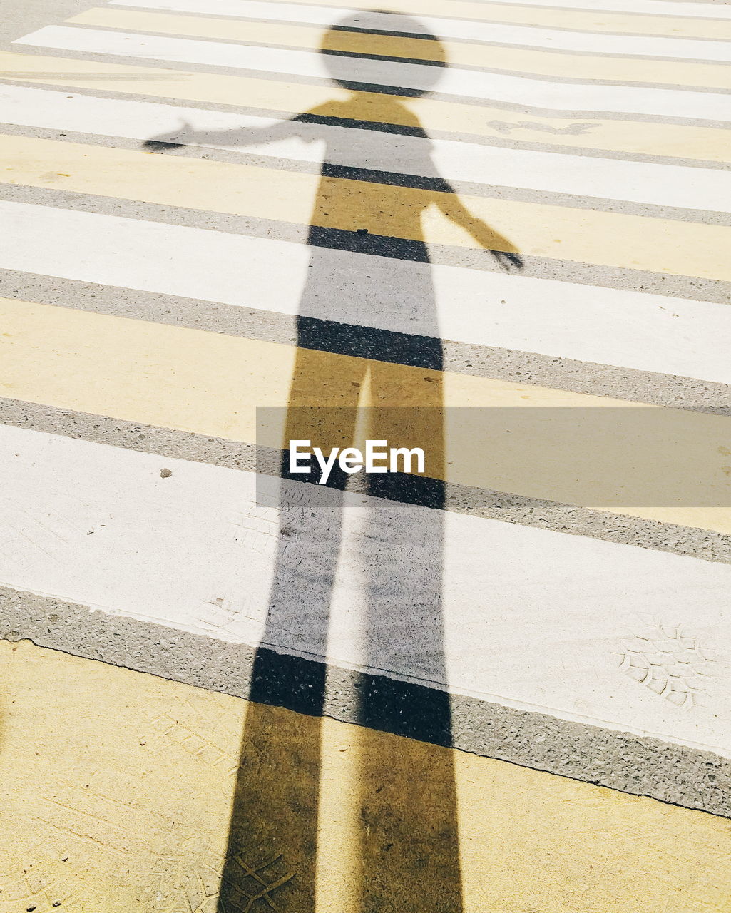 Shadow of person on zebra crossing