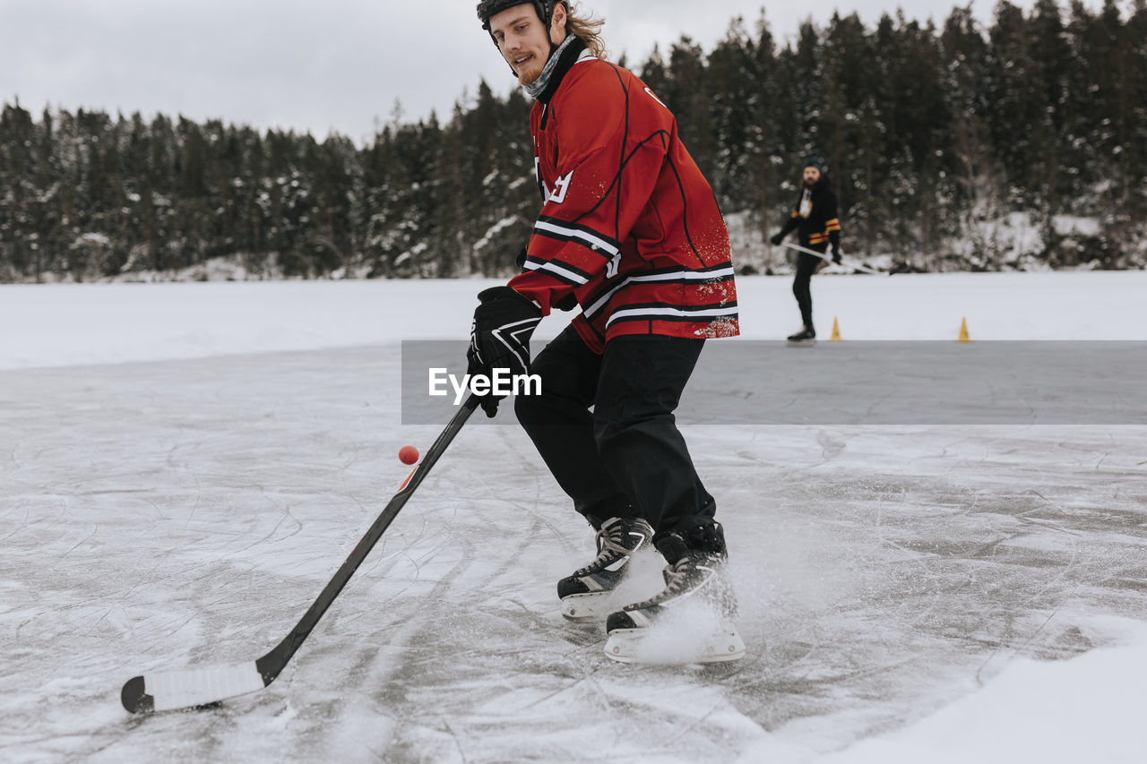 Man playing hockey on frozen lake