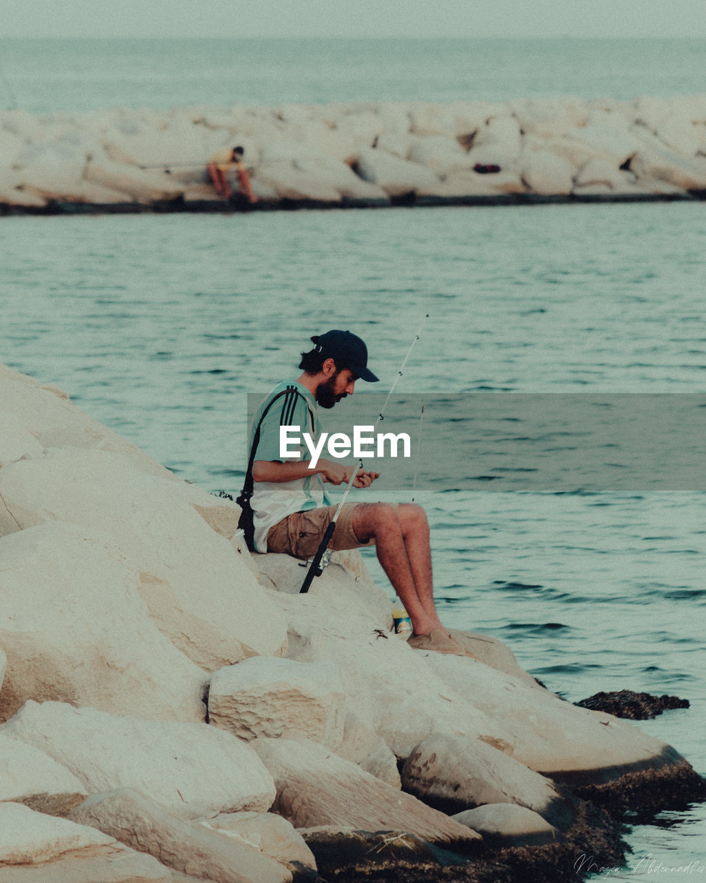 MAN SURFING ON ROCK AT SEA SHORE