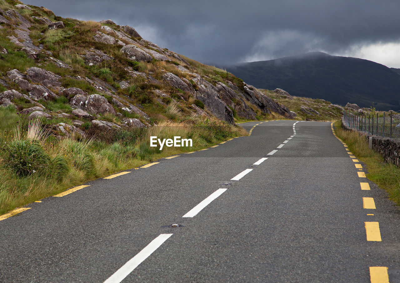 Road by mountains against sky