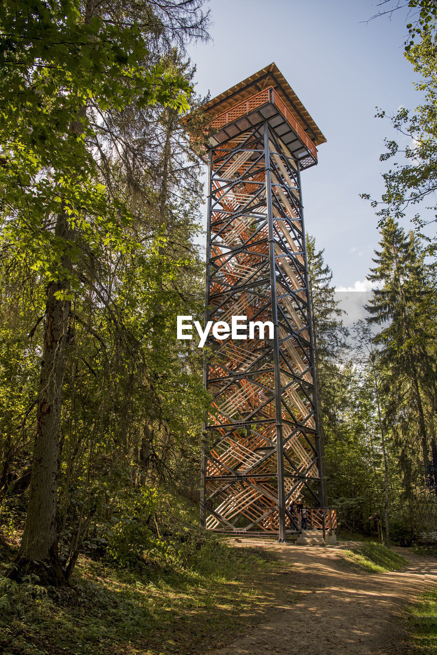 LOW ANGLE VIEW OF BUILDING AMIDST TREES AGAINST SKY