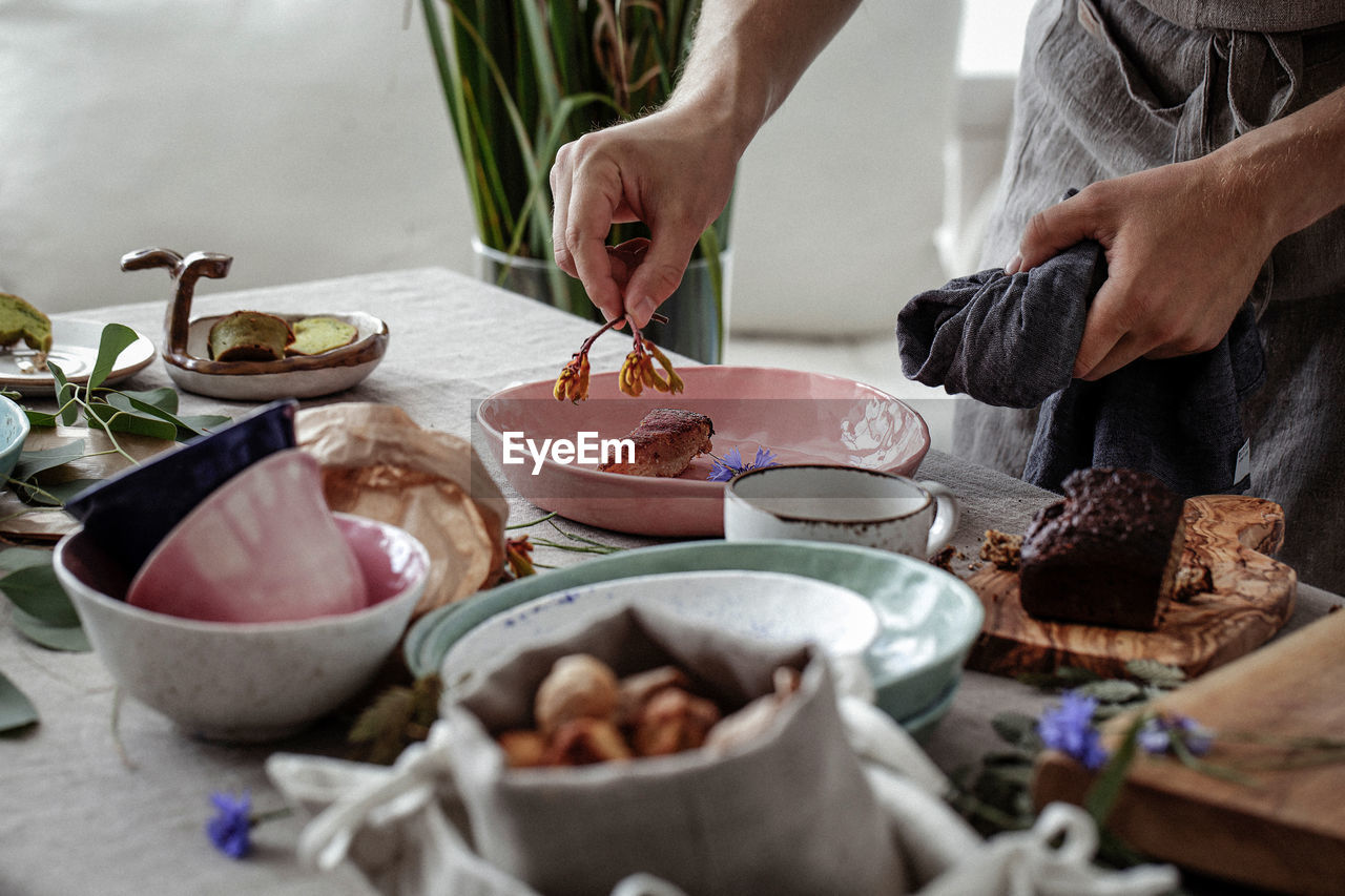 MIDSECTION OF MAN PREPARING FOOD IN KITCHEN