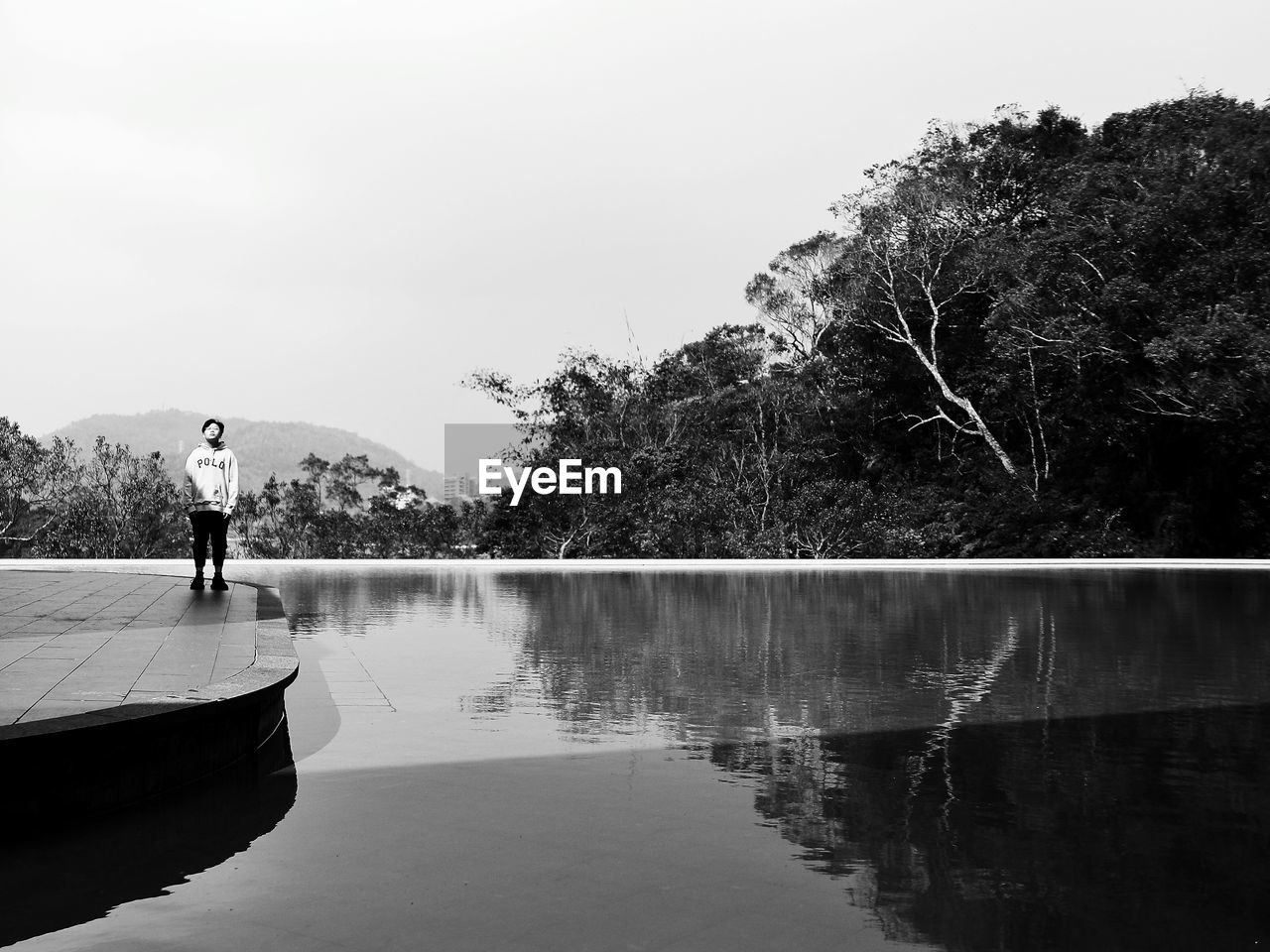 REAR VIEW OF PERSON STANDING BY LAKE