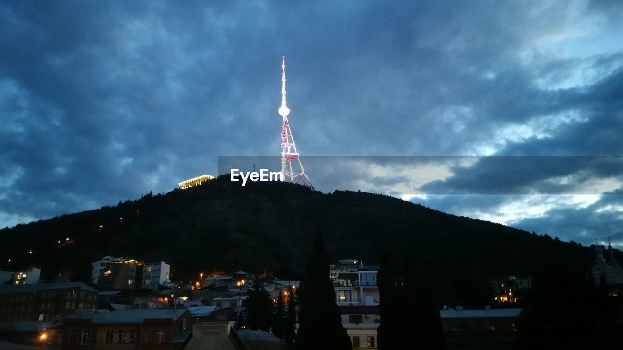 COMMUNICATIONS TOWER AGAINST CLOUDY SKY AT NIGHT