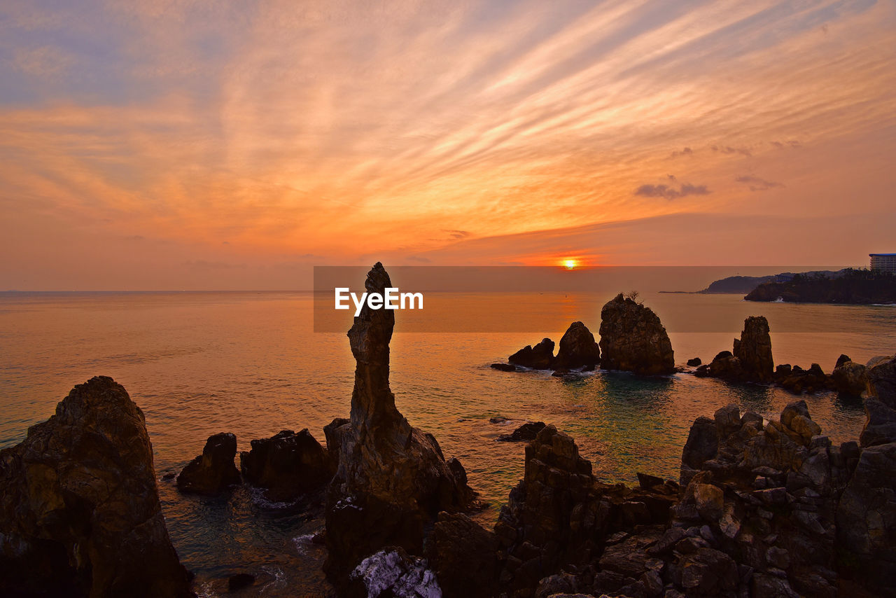 SCENIC VIEW OF ROCKS AT SUNSET