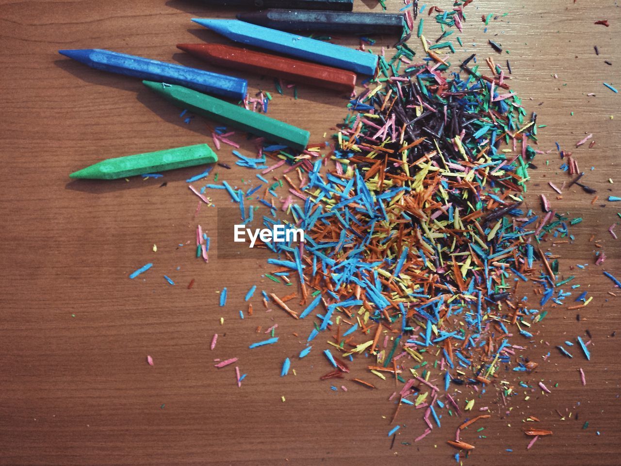 Directly above view of colorful crayon shavings on table