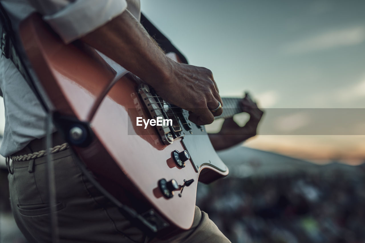 Cropped hand of man playing guitar