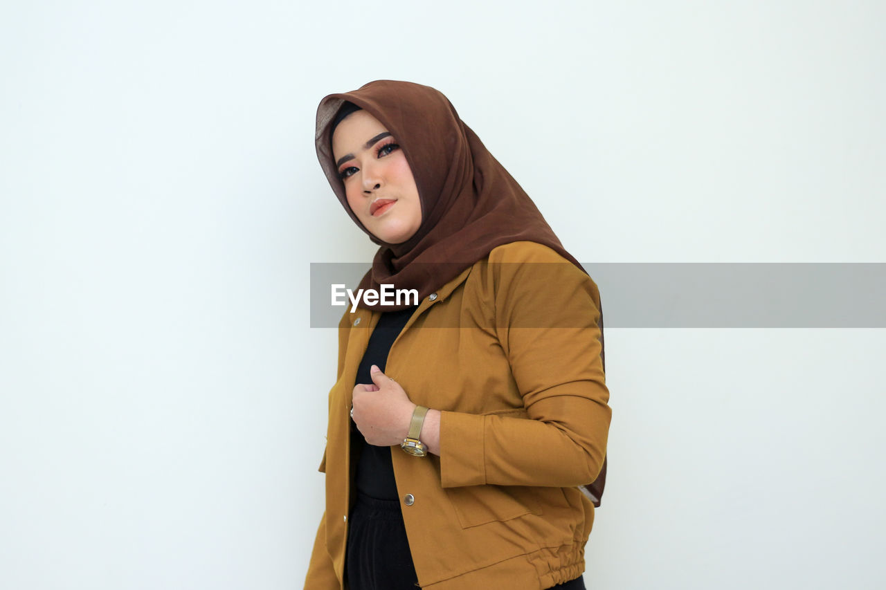 Young woman looking away against white background