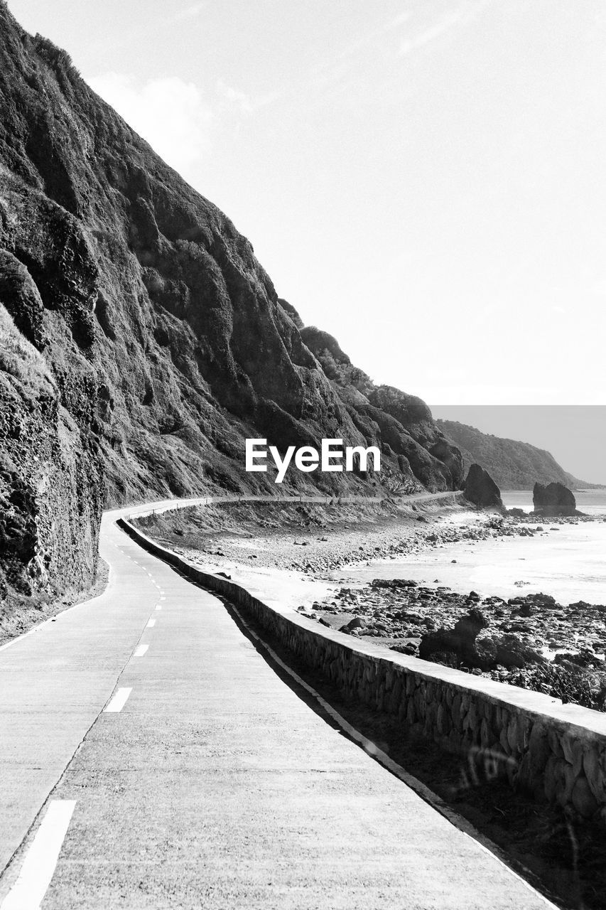 Empty road by mountain against sky