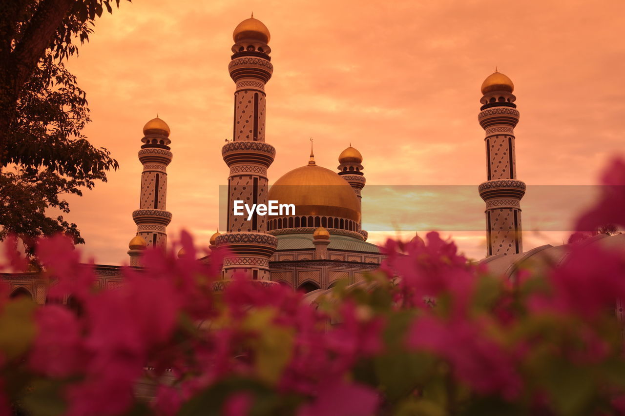 Low angle view of mosque against cloudy sky