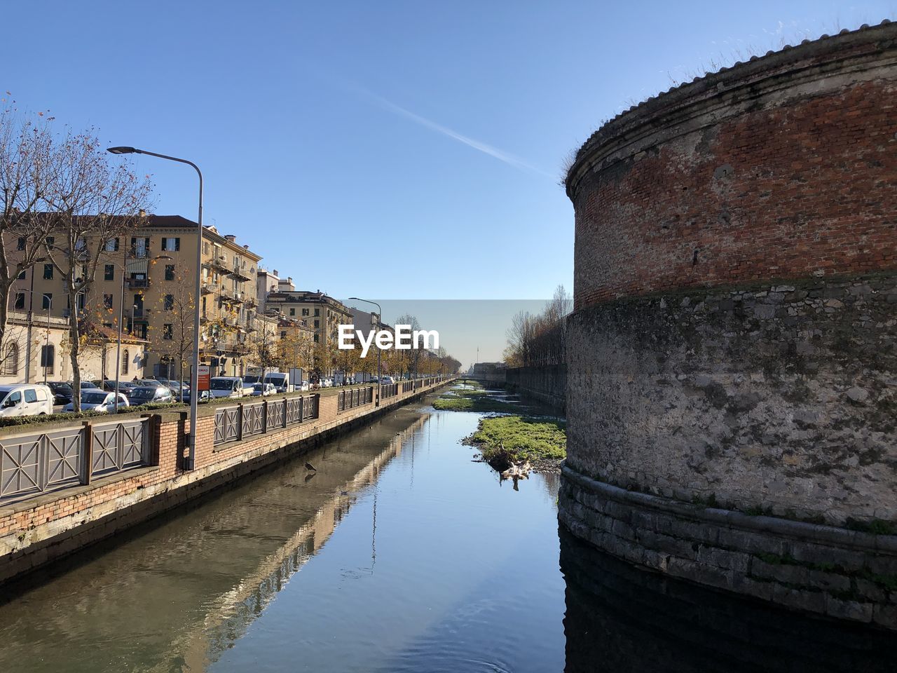 CANAL AMIDST BUILDINGS AGAINST SKY