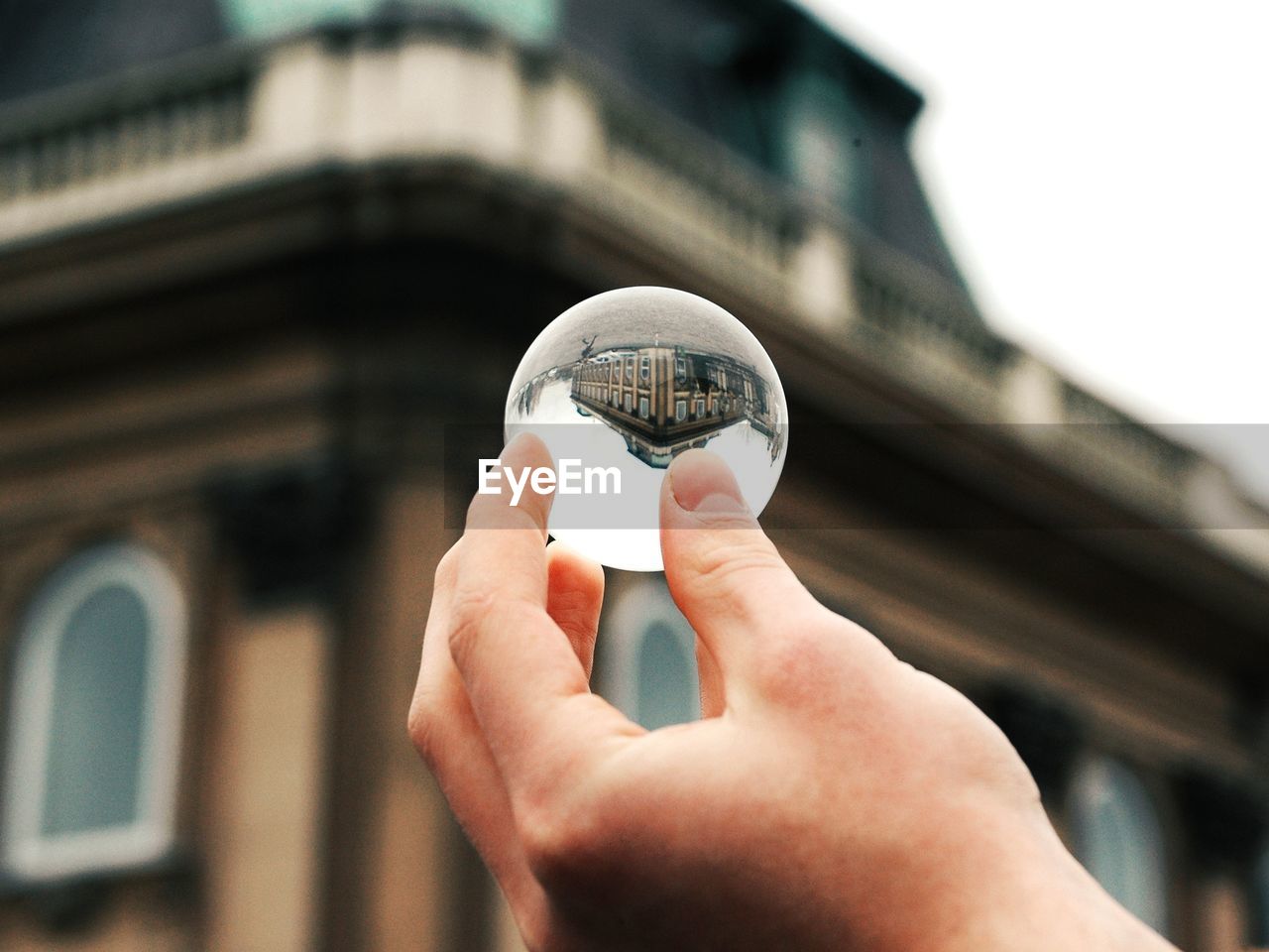 Midsection of person holding glass against blurred background