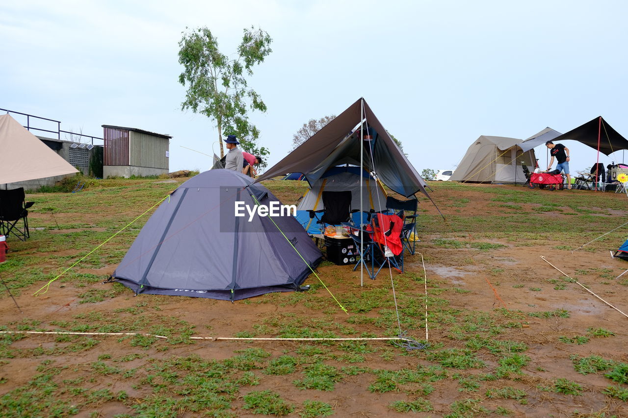 tent, camping, architecture, sky, built structure, nature, building exterior, building, house, adventure, landscape, environment, grass, plant, day, hut, outdoors, land, lifestyles, leisure activity, travel destinations, travel, men, adult, vacation, holiday, trip, residential district