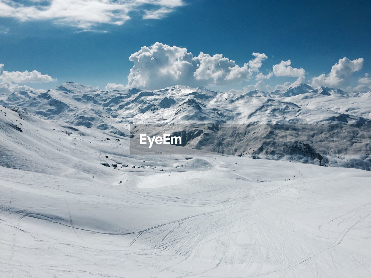 Scenic view of snow covered mountains against cloudy sky