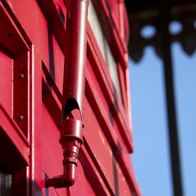 LOW ANGLE VIEW OF RED OBJECT ON WALL