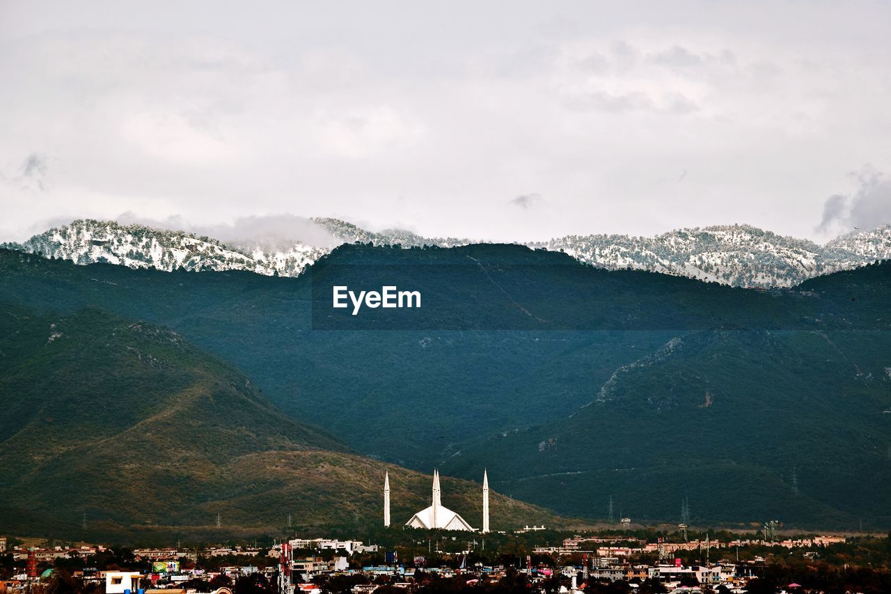 Scenic view of mountains by shah faisal masjid against sky