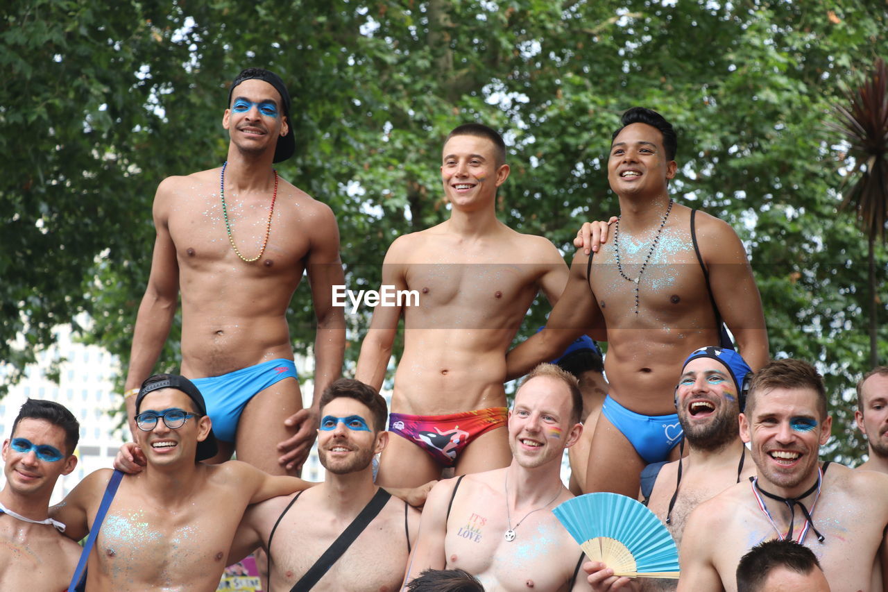 PORTRAIT OF A SMILING YOUNG MAN AND WOMAN IN BIKINI