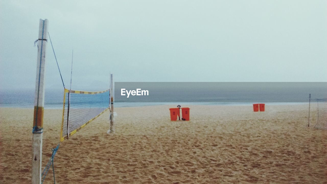 Volleyball net at beach against sky