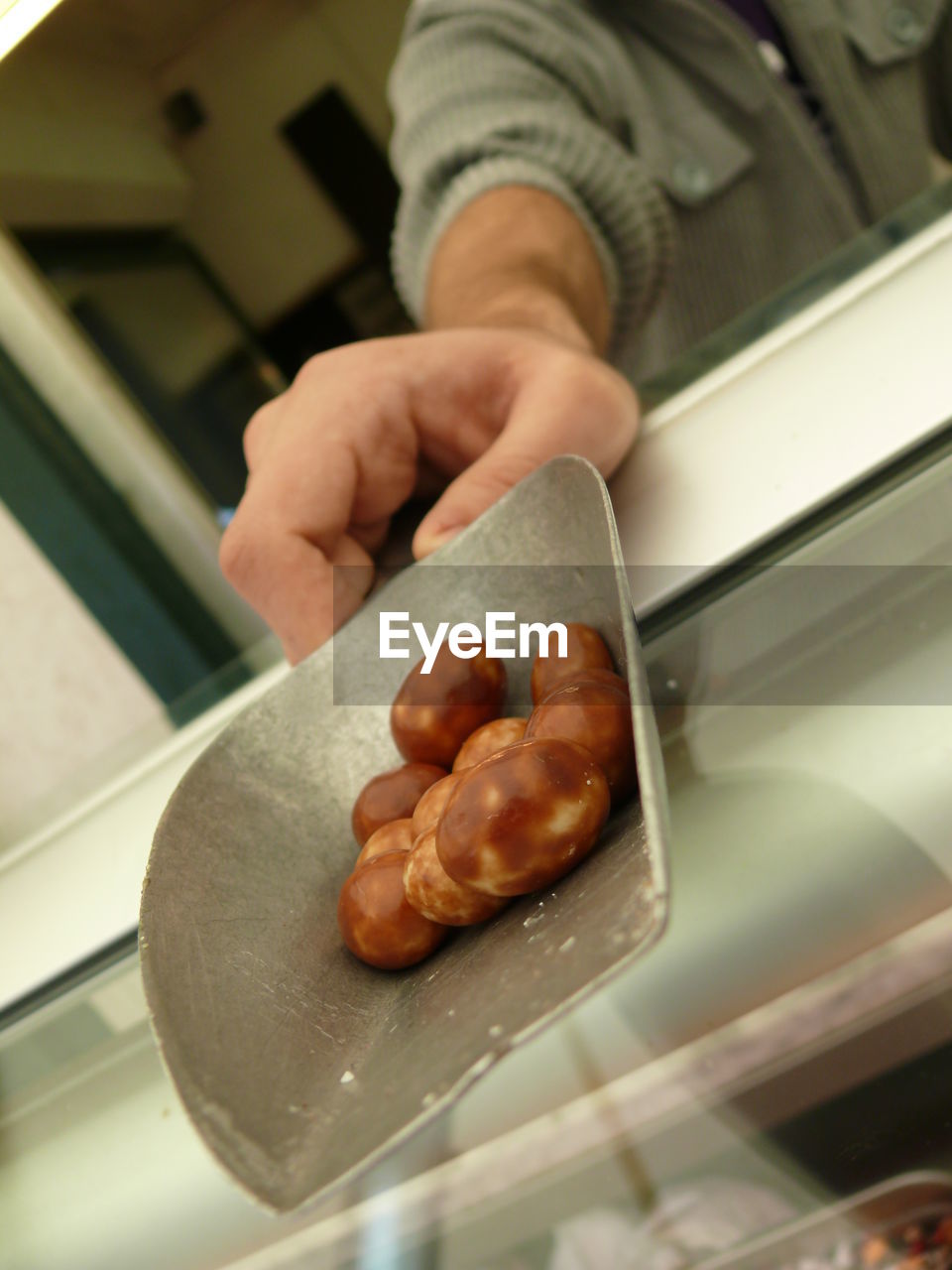 Cropped image of hand holding container with food