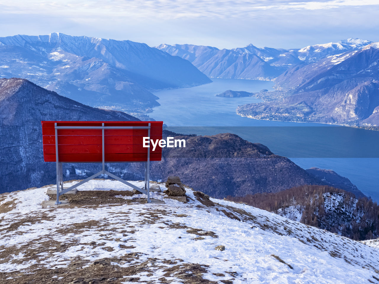 Big red bench on the landscape of lake como