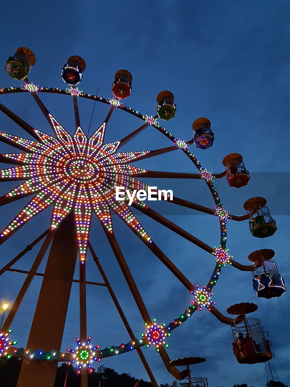 LOW ANGLE VIEW OF ILLUMINATED FERRIS WHEEL AGAINST SKY