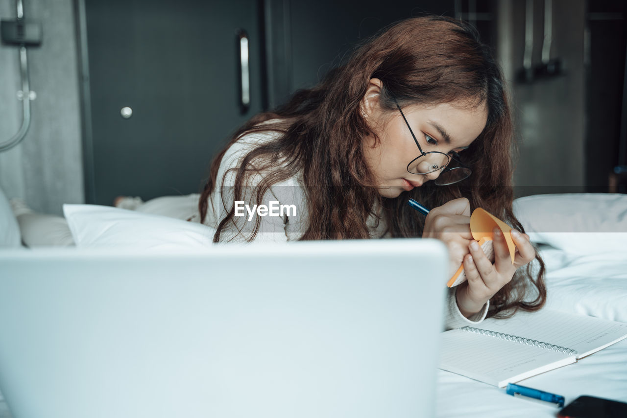 Woman using mobile phone while sitting on table