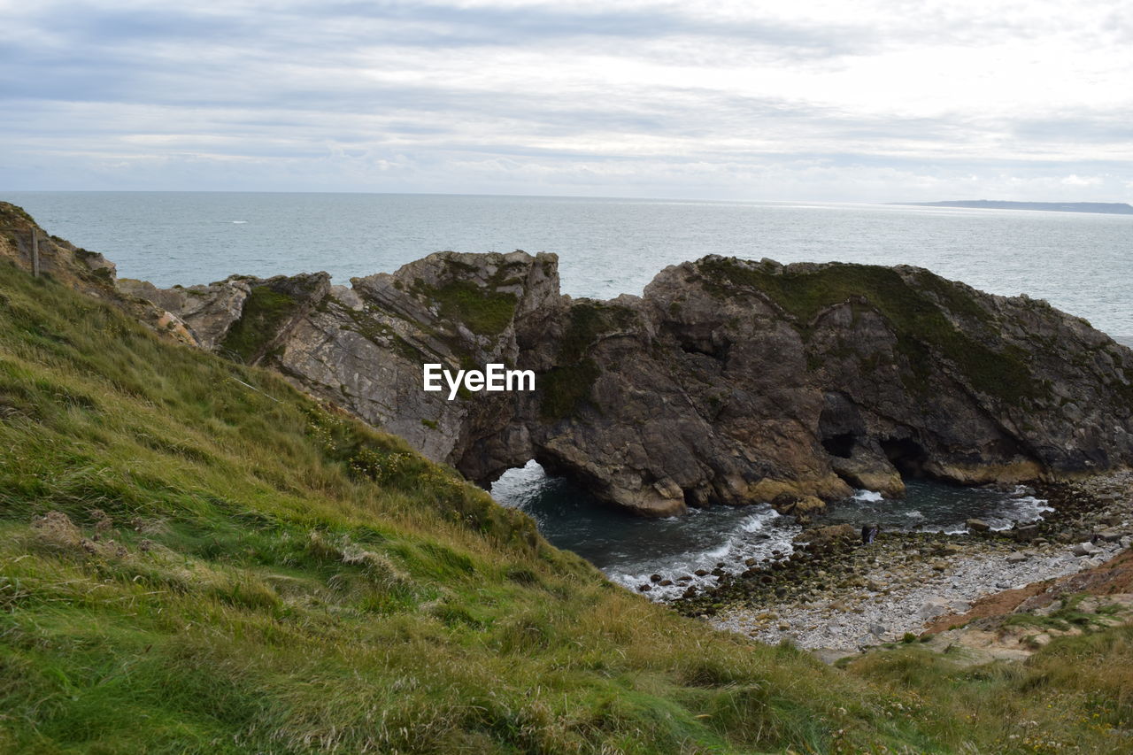 Rock formation in sea against sky