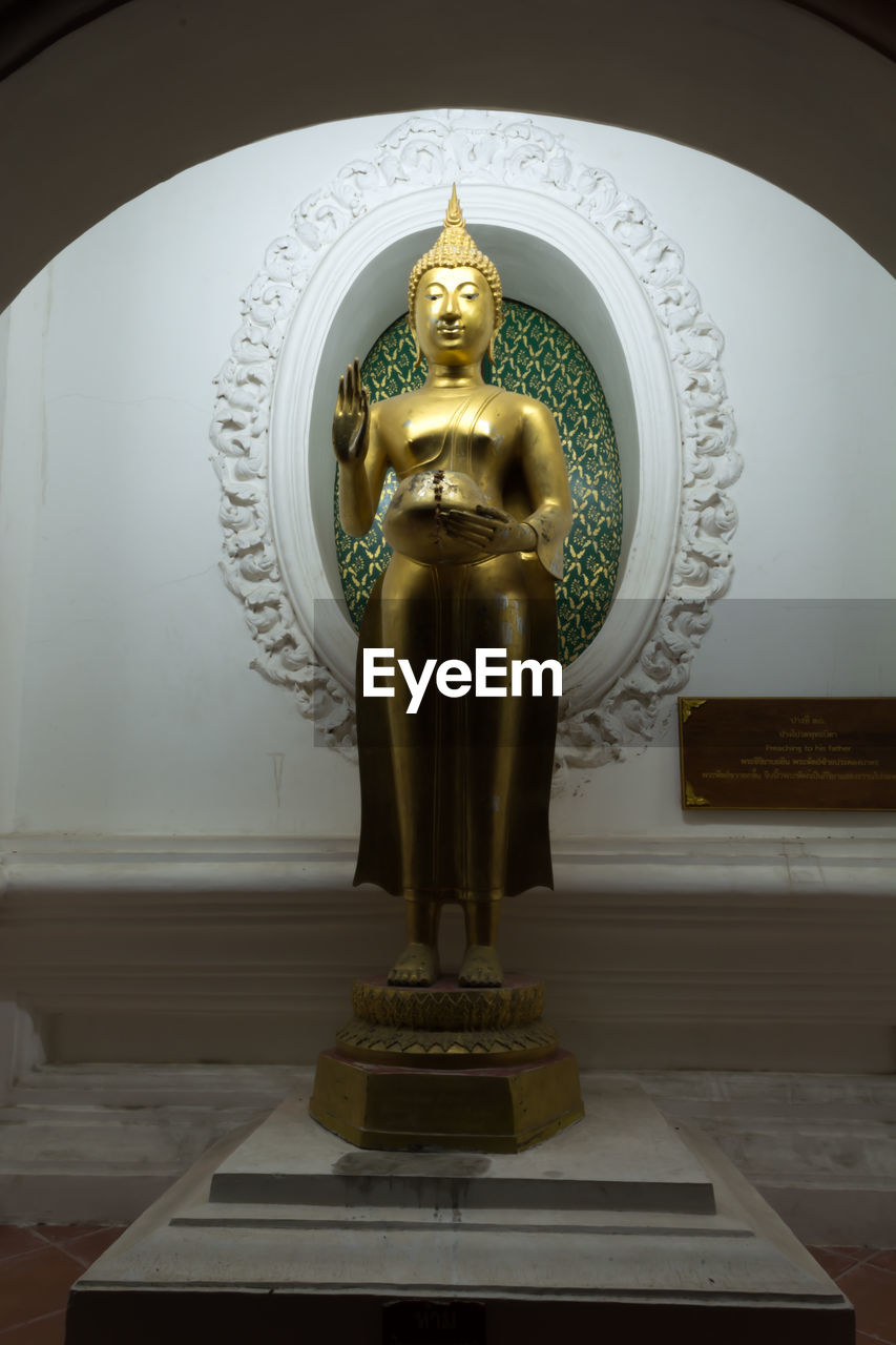 LOW ANGLE VIEW OF BUDDHA STATUE AGAINST TEMPLE