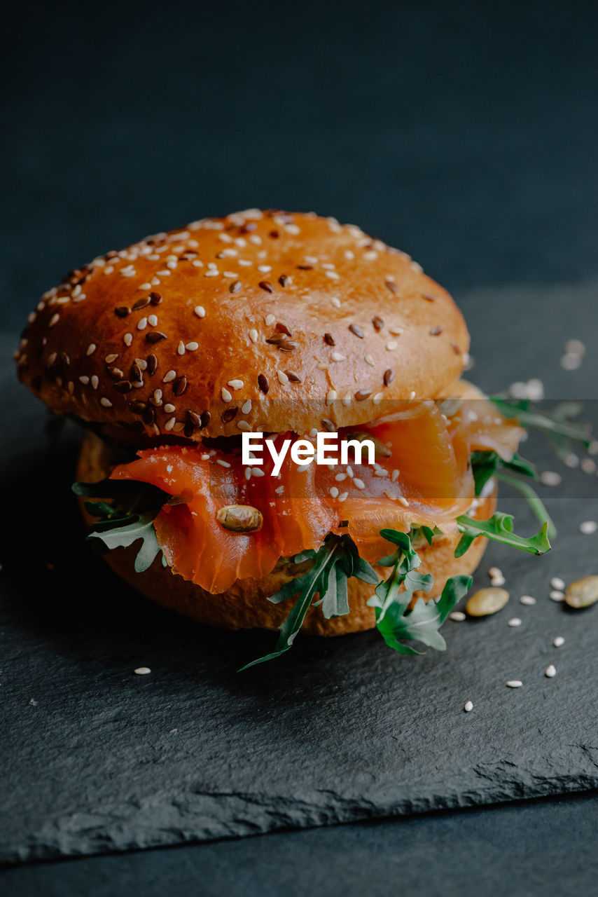 CLOSE-UP OF BURGER IN CONTAINER AGAINST BLACK BACKGROUND