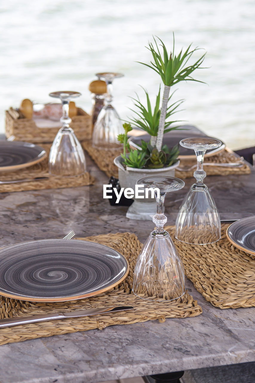 Beautiful served table of a modern cafe by the sea with dishes and flowers