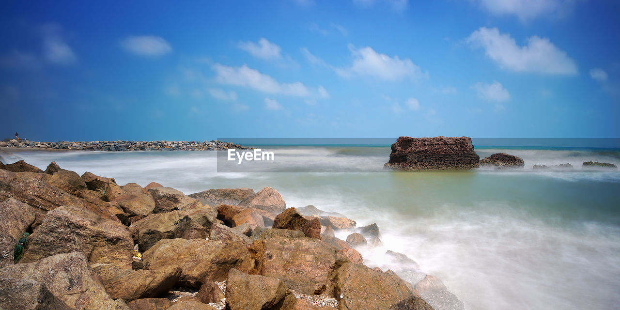 PANORAMIC VIEW OF ROCKS ON BEACH AGAINST SKY