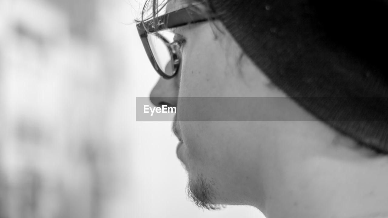 CLOSE-UP SIDE VIEW OF YOUNG MAN IN EYEGLASSES