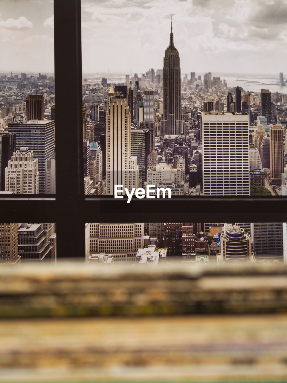 Pile of vinyl record sleeves in apartment with nyc skyline in background