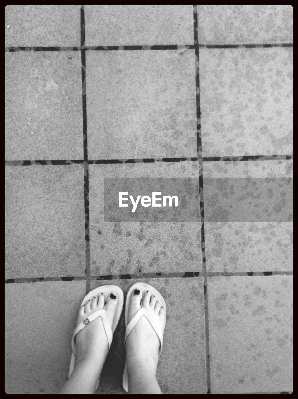 Low section of woman standing on tiled floor