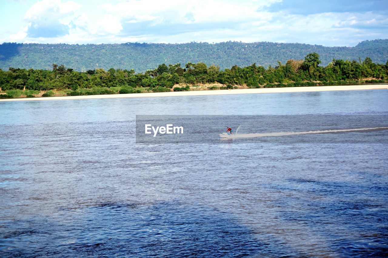 Scenic view of person riding speedboat on sea