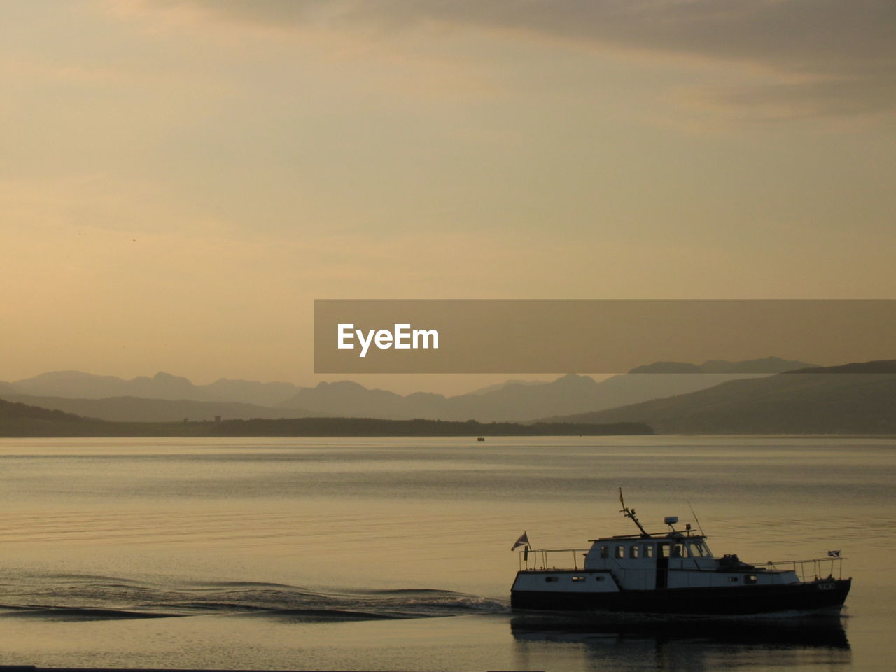 Boat moored on sea against sky during sunset