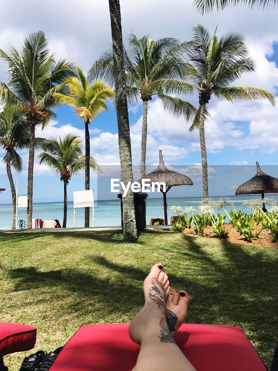 Low section of woman relaxing at beach