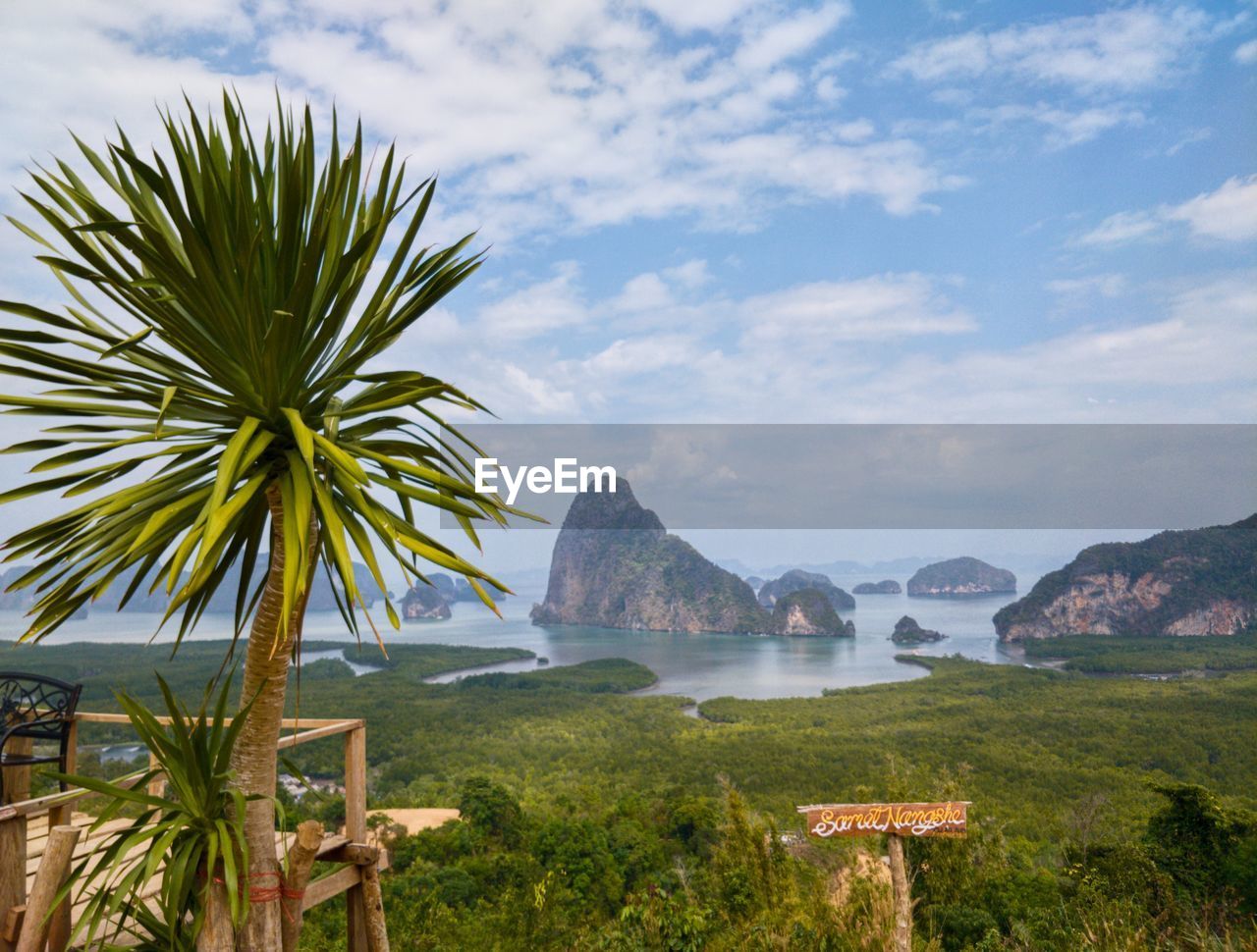 Scenic view of sea by mountains against sky