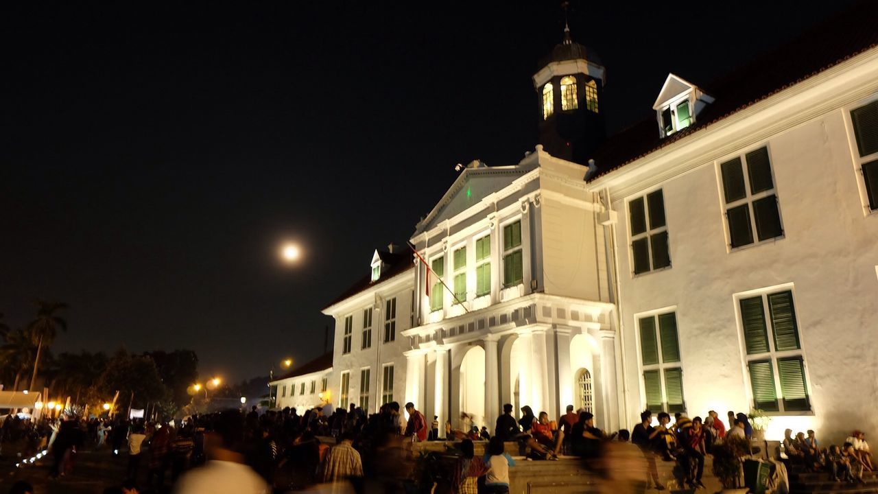 Facade of jakarta history museum with crowd at night