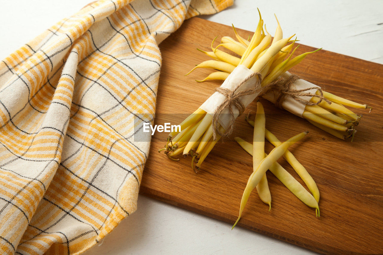food, food and drink, indoors, yellow, high angle view, healthy eating, no people, wellbeing, freshness, still life, pasta, wood, cutting board, produce, studio shot, italian food, raw food, vegetable, ingredient, dish, table, dish towel, close-up
