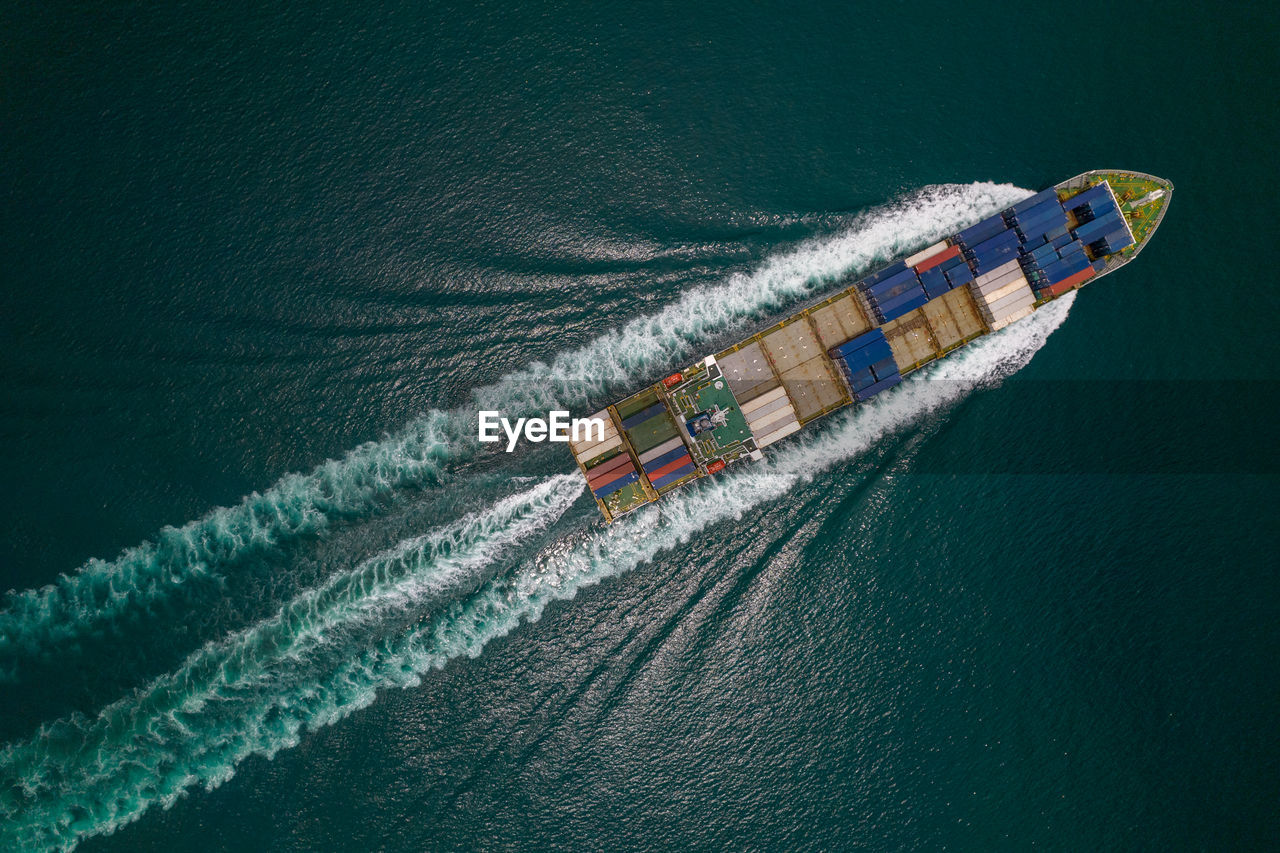 HIGH ANGLE VIEW OF DECK CHAIRS ON SEA