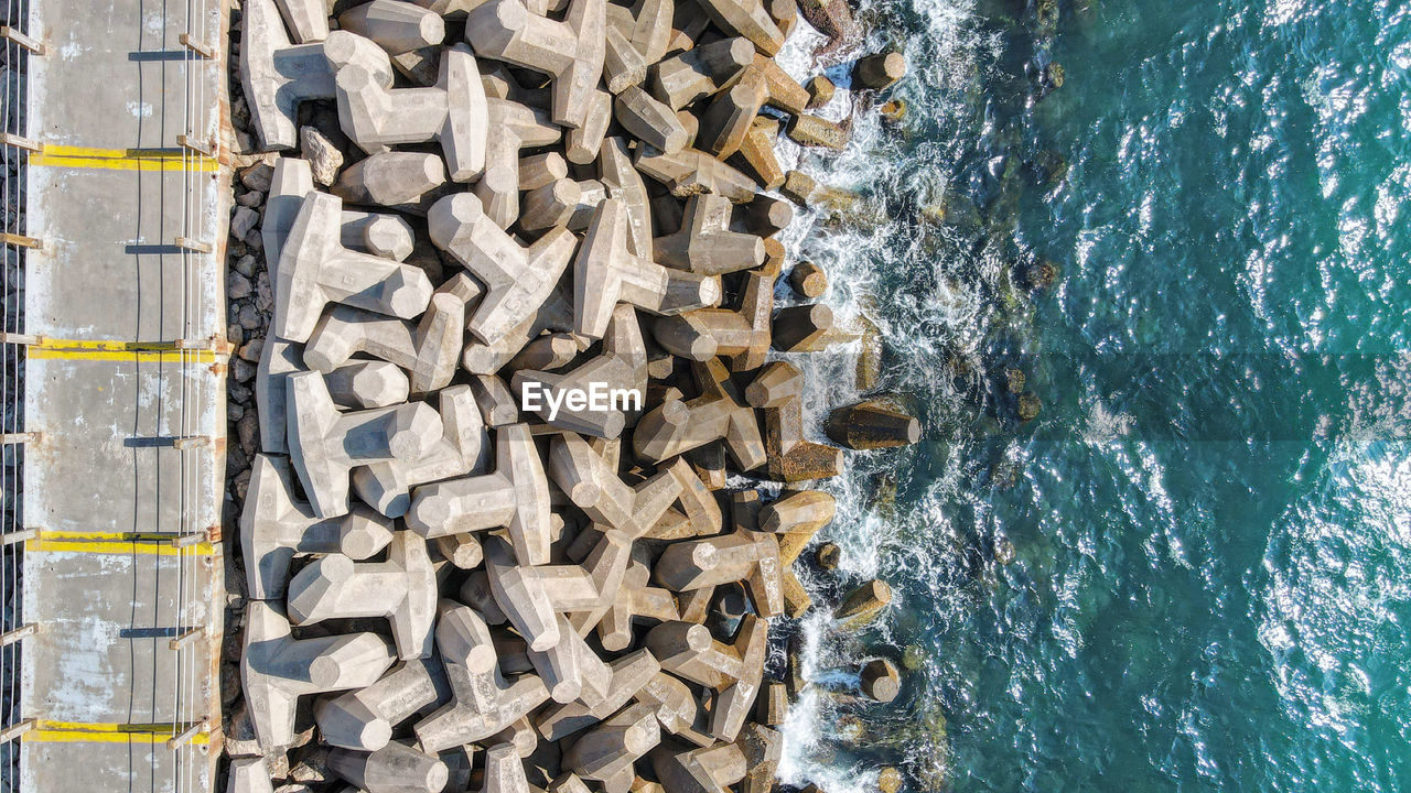 High angle view of stack of firewood by sea