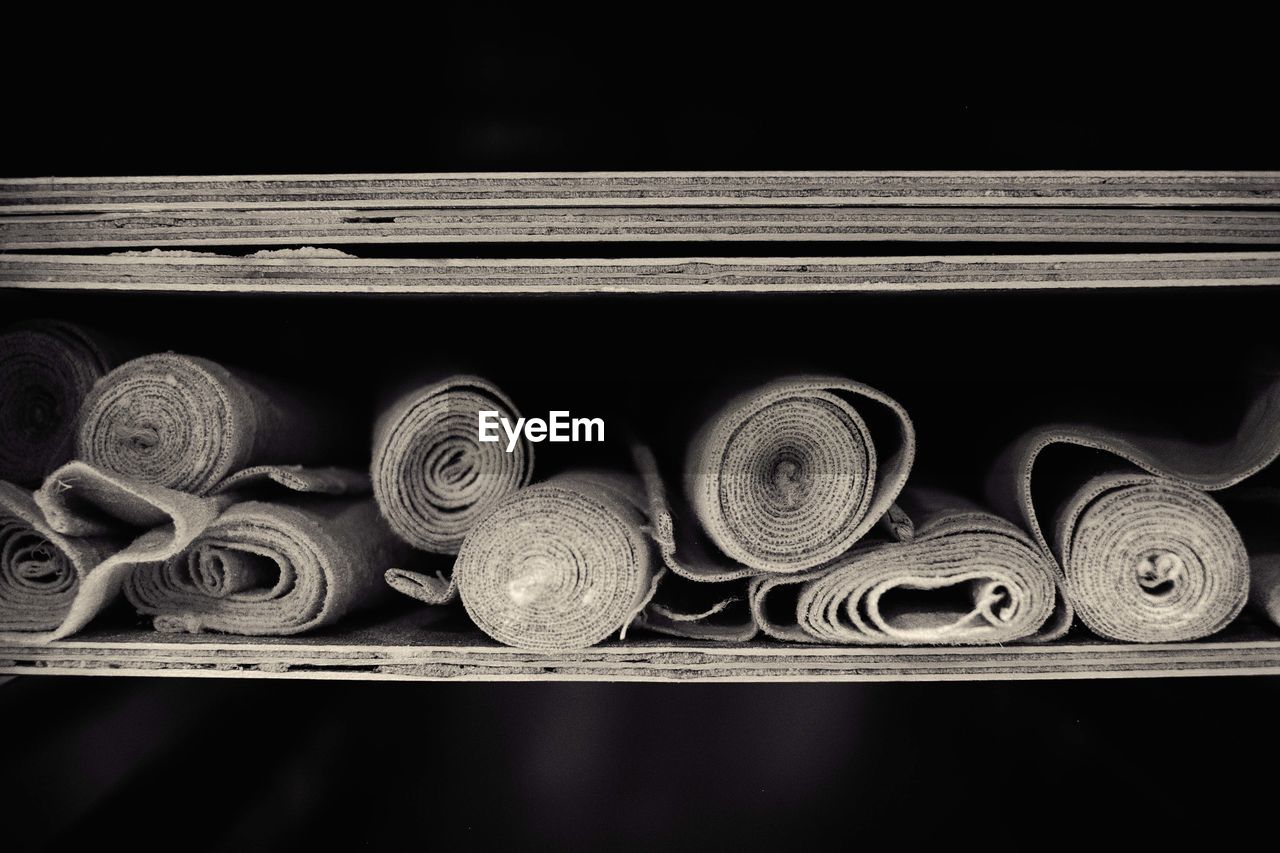 Close-up of rolled up fabrics in shelf at bakery