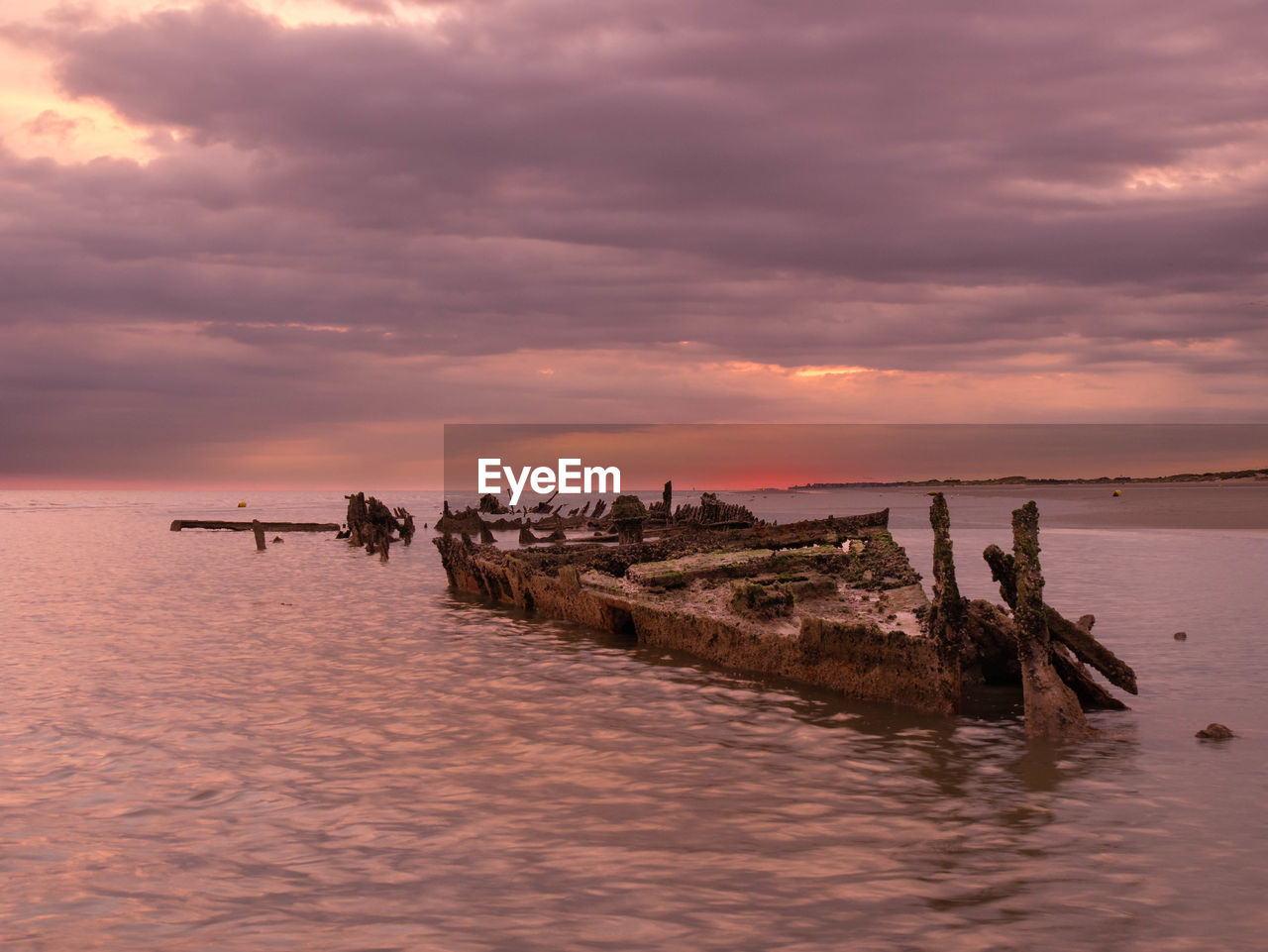 Sunrise with a sunken shipwreck from world war ii close to the beach