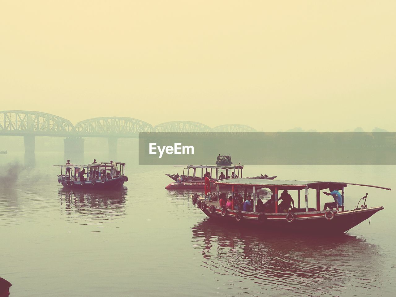 PEOPLE ON BOAT IN WATER AGAINST SKY